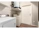 Bright laundry room with modern washer, dryer, and water heater, plus storage shelving at 14250 W Wigwam Blvd # 812, Litchfield Park, AZ 85340
