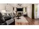Cozy living room featuring hardwood floors, a fireplace, and a stylish gray sofa at 14250 W Wigwam Blvd # 812, Litchfield Park, AZ 85340
