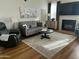 Relaxing living room with hardwood floors, a comfortable gray sofa, and a fireplace at 14250 W Wigwam Blvd # 812, Litchfield Park, AZ 85340