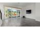 Open living room with tile floors, large windows, and a mounted flat-screen TV at 1717 E Morten Ave # 7, Phoenix, AZ 85020