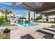 View of a luxury pool area with lounge chairs, palm trees, desert landscaping, and modern condo buildings at 1717 E Morten Ave # 7, Phoenix, AZ 85020