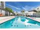 Community pool is surrounded by modern condos with desert landscaping, lounge chairs, and palm trees at 1717 E Morten Ave # 7, Phoenix, AZ 85020