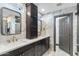 This bathroom is equipped with dual sinks, black cabinetry, marble backsplash and flooring at 1744 E Luke Ave, Phoenix, AZ 85016