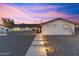 Charming home featuring modern walkway lighting and decorative block wall, set against a vibrant sky at 1744 E Luke Ave, Phoenix, AZ 85016