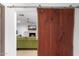 Rustic barn door opens to a cozy living room with a fireplace and comfortable green seating at 1744 E Luke Ave, Phoenix, AZ 85016