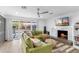 Bright living room featuring a green sofa, marble fireplace, and large sliding glass doors to backyard at 1744 E Luke Ave, Phoenix, AZ 85016