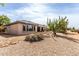 Backyard view of the home with covered patio and desert landscaping at 18140 N Saddle Ridge Dr, Surprise, AZ 85374