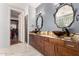 Bathroom featuring double vanity with vessel sinks, designer mirrors, and an adjacent walk-in closet at 18140 N Saddle Ridge Dr, Surprise, AZ 85374
