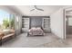 Comfortable bedroom with a ceiling fan, stylish furniture, and bright natural light from the large windows at 18140 N Saddle Ridge Dr, Surprise, AZ 85374