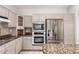 Well-equipped kitchen featuring stainless steel refrigerator, tile backsplash and granite countertops at 18140 N Saddle Ridge Dr, Surprise, AZ 85374
