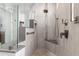 Elegant walk-in shower featuring custom tile work, a glass enclosure, and built-in shelving at 18140 N Saddle Ridge Dr, Surprise, AZ 85374