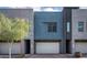 Modern townhome boasts a striking blue facade, garage, and well-maintained landscaping at 1953 W Kinfield Trl, Phoenix, AZ 85085