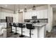 Stylish kitchen features white cabinetry, stainless steel appliances, and a sleek breakfast bar at 1953 W Kinfield Trl, Phoenix, AZ 85085