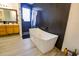 Stylish bathroom with a stand-alone tub, luxury vinyl flooring, and a window for plenty of light at 2135 W Vineyard Rd, Phoenix, AZ 85041