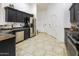 Kitchen with stainless steel appliances, dark cabinets, and tiled floors at 2135 W Vineyard Rd, Phoenix, AZ 85041