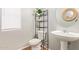 Clean half bathroom featuring a pedestal sink and a decorative shelf at 22644 W Mohave St, Buckeye, AZ 85326