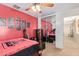 Inviting bedroom featuring vibrant red walls, ceiling fan, and a mirrored closet at 22644 W Mohave St, Buckeye, AZ 85326
