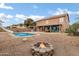This backyard has a large outdoor pool with a slide and a cozy fire pit area at 28014 N Jade St, San Tan Valley, AZ 85143