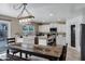 Modern kitchen featuring white cabinets, farm sink, and a rustic wooden table with chairs at 28014 N Jade St, San Tan Valley, AZ 85143