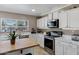 Updated kitchen with white cabinets, marble countertops, and stainless steel appliances at 28014 N Jade St, San Tan Valley, AZ 85143
