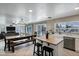 Open-concept living and dining area with a long wooden table and backyard views at 28014 N Jade St, San Tan Valley, AZ 85143