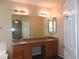 Bright bathroom featuring double sinks with granite countertops, wood cabinets and a large mirror at 29673 N 120Th Ln, Peoria, AZ 85383