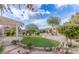 A well-manicured backyard with artificial turf, a pergola, and desert landscaping at 32160 N Dog Leg Ct, San Tan Valley, AZ 85143