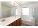 A bathroom is shown with double sinks, a large tub and a glass shower enclosure at 32160 N Dog Leg Ct, San Tan Valley, AZ 85143