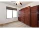 A bedroom is shown with brown carpet, a ceiling fan and a built-in Murphy bed and cabinets at 32160 N Dog Leg Ct, San Tan Valley, AZ 85143