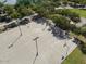 Aerial view of the outdoor basketball court with multiple hoops surrounded by lush trees and sidewalks at 36971 W Santa Maria St, Maricopa, AZ 85138