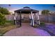 This gazebo features a brick patio, seating, and privacy curtains at 3744 E Evans Dr, Phoenix, AZ 85032