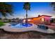 This in-ground pool has custom lighting, a palm tree, and patio area at 3744 E Evans Dr, Phoenix, AZ 85032