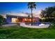 Backyard pool with lighting, palm tree, patio, and lush landscaping at 3744 E Evans Dr, Phoenix, AZ 85032
