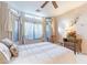 Serene bedroom featuring large windows with neutral curtains, a queen bed, and a cozy reading corner at 440 S Val Vista Dr # 52, Mesa, AZ 85204