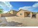 An exterior view shows the backyard, patio and tan home with blue skies at 4613 W Ellis St, Laveen, AZ 85339