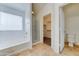 Bathroom featuring tile floors, standalone tub, glass shower, and walk-in closet at 4613 W Ellis St, Laveen, AZ 85339