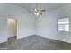 Bedroom featuring carpet, neutral walls, and a ceiling fan with view to hallway at 4613 W Ellis St, Laveen, AZ 85339