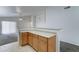 Kitchen featuring wooden cabinets, bar seating, and views into the living room at 4613 W Ellis St, Laveen, AZ 85339