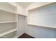 Bright walk-in closet features built-in shelving and wooden rods for organized storage solutions at 4613 W Ellis St, Laveen, AZ 85339