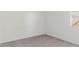 A minimalist bedroom featuring neutral carpet, a window, and white walls at 5742 E Smeaton Pl, San Tan Valley, AZ 85140