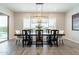 Elegant dining room with a modern chandelier, dark wood table, and access to the outdoor patio at 6130 E Bramble Berry Ln, Cave Creek, AZ 85331