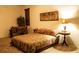 Cozy bedroom featuring a patterned bedspread, dark wood accents, and warm lighting, creating a relaxing atmosphere at 6909 S 257Th Dr, Buckeye, AZ 85326