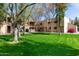 Landscaped exterior view showcasing a condo building with well-maintained lawns and mature shade trees at 715 S Extension Rd # 70, Mesa, AZ 85210