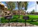 Outdoor grills in a common area, with an exterior view of condo buildings and a lush green lawn at 715 S Extension Rd # 70, Mesa, AZ 85210