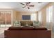 Cozy living room with a ceiling fan, neutral walls, and a leather sofa at 7838 W Palm Ln, Phoenix, AZ 85035