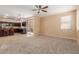 Open concept living area with ceiling fan, adjacent to the kitchen, featuring tile flooring and a sliding glass door at 7838 W Palm Ln, Phoenix, AZ 85035