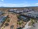 An aerial view showcases a desert neighborhood with homes surrounding a community tennis court at 8140 E June St, Mesa, AZ 85207