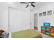 Bedroom features a closet, a ceiling fan, a TV, carpeted floor and some toys at 8140 E June St, Mesa, AZ 85207