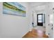 Bright entryway featuring wood floors, white walls, and artwork leading to a modern home interior at 8140 E June St, Mesa, AZ 85207