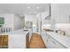 Bright kitchen features white cabinets, quartz countertops, stainless appliances, and wood-look floors at 8140 E June St, Mesa, AZ 85207